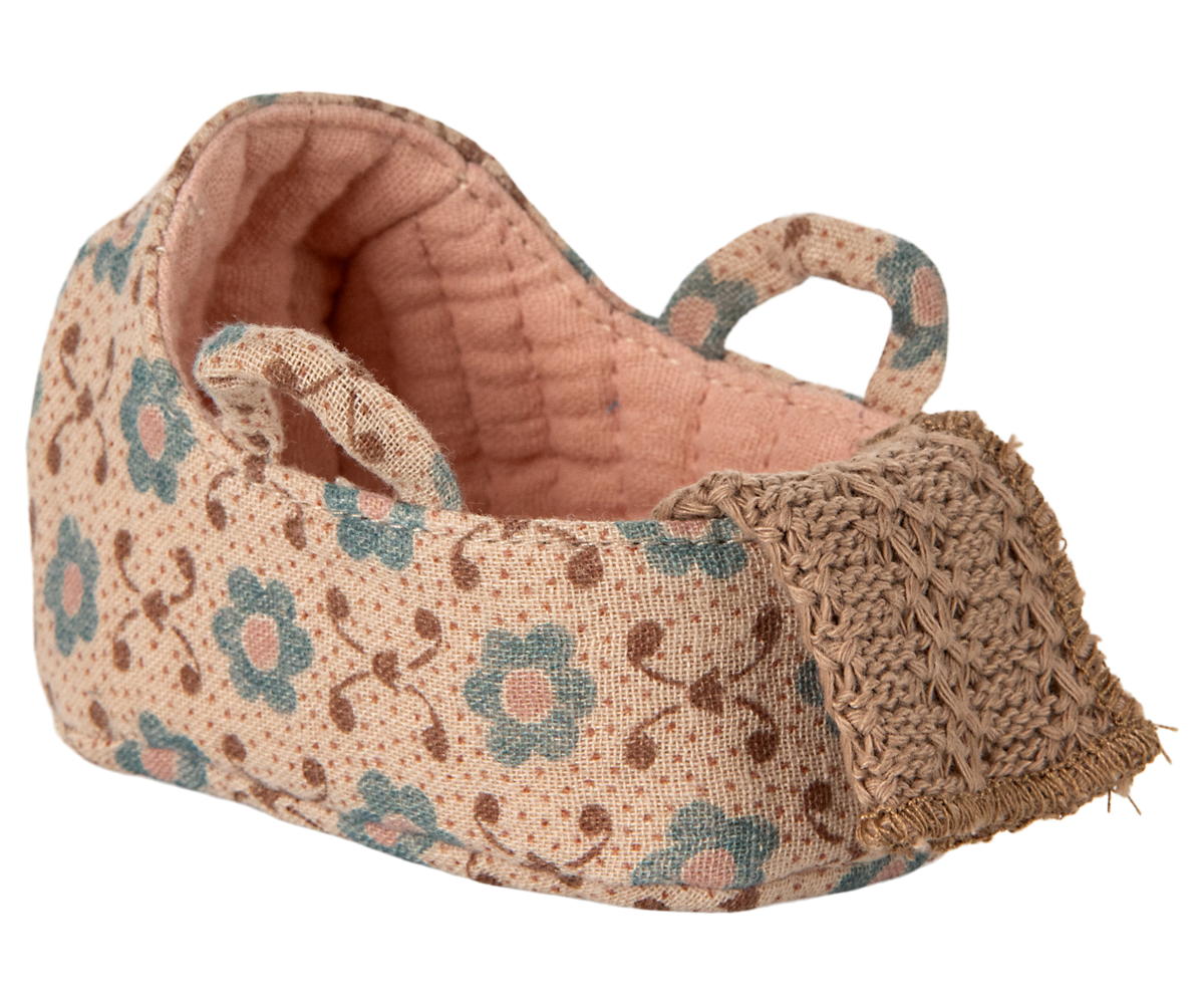 Floral-patterned fabric basket with a textured edge on a white background