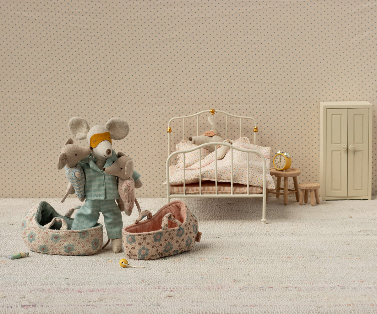 Miniature bedroom scene with toys and furniture on a neutral background