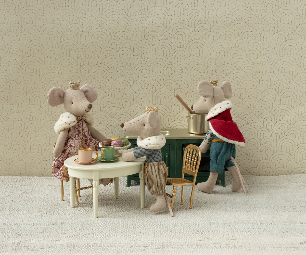 Four toy mice with human-like clothing and accessories in a room setting.