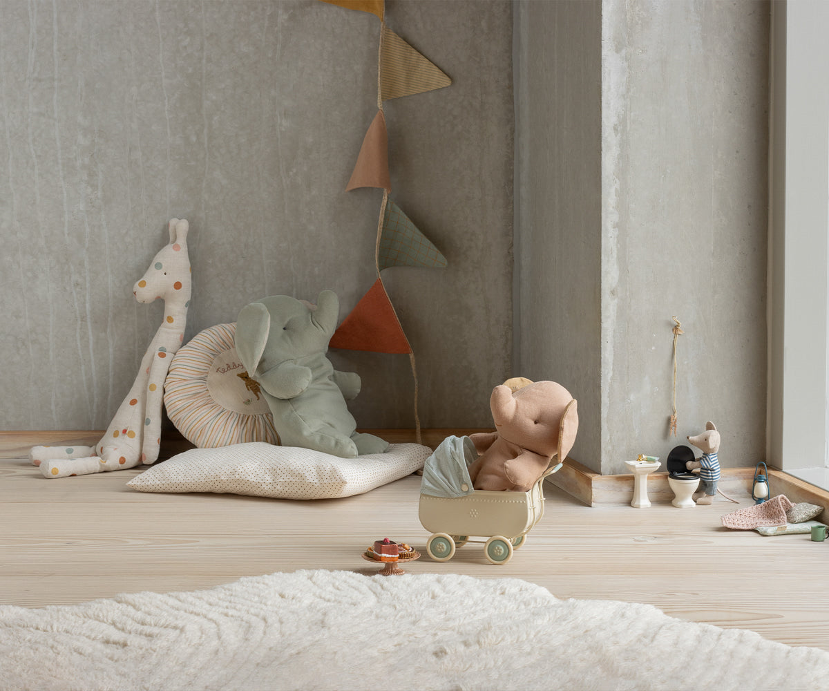 Children's room with toys and decorative items on a wooden floor.