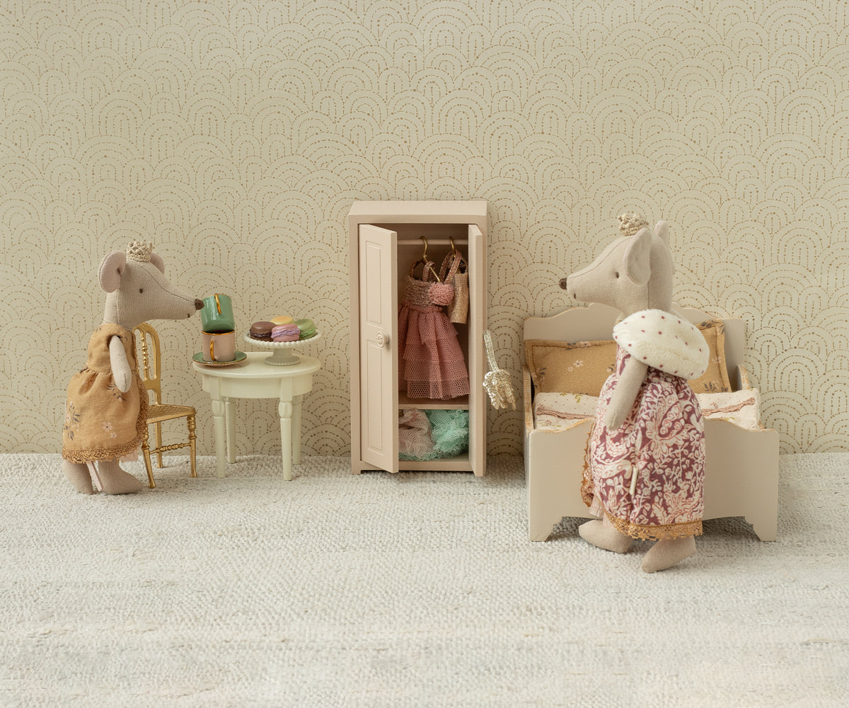 Miniature scene with toy mice in a room setting, including a wardrobe and furniture.