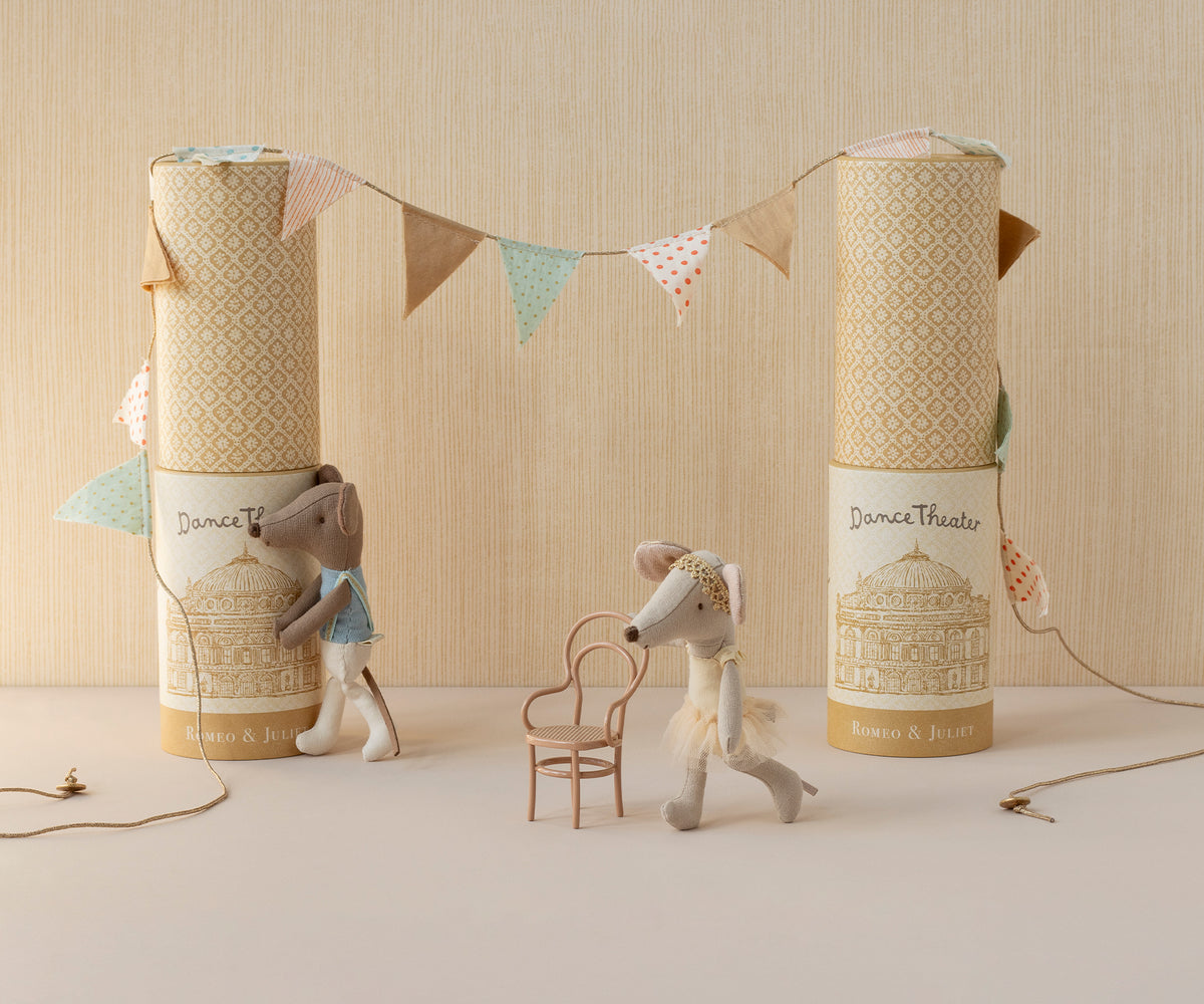 Two toy mice with decorative boxes and a banner on a neutral background