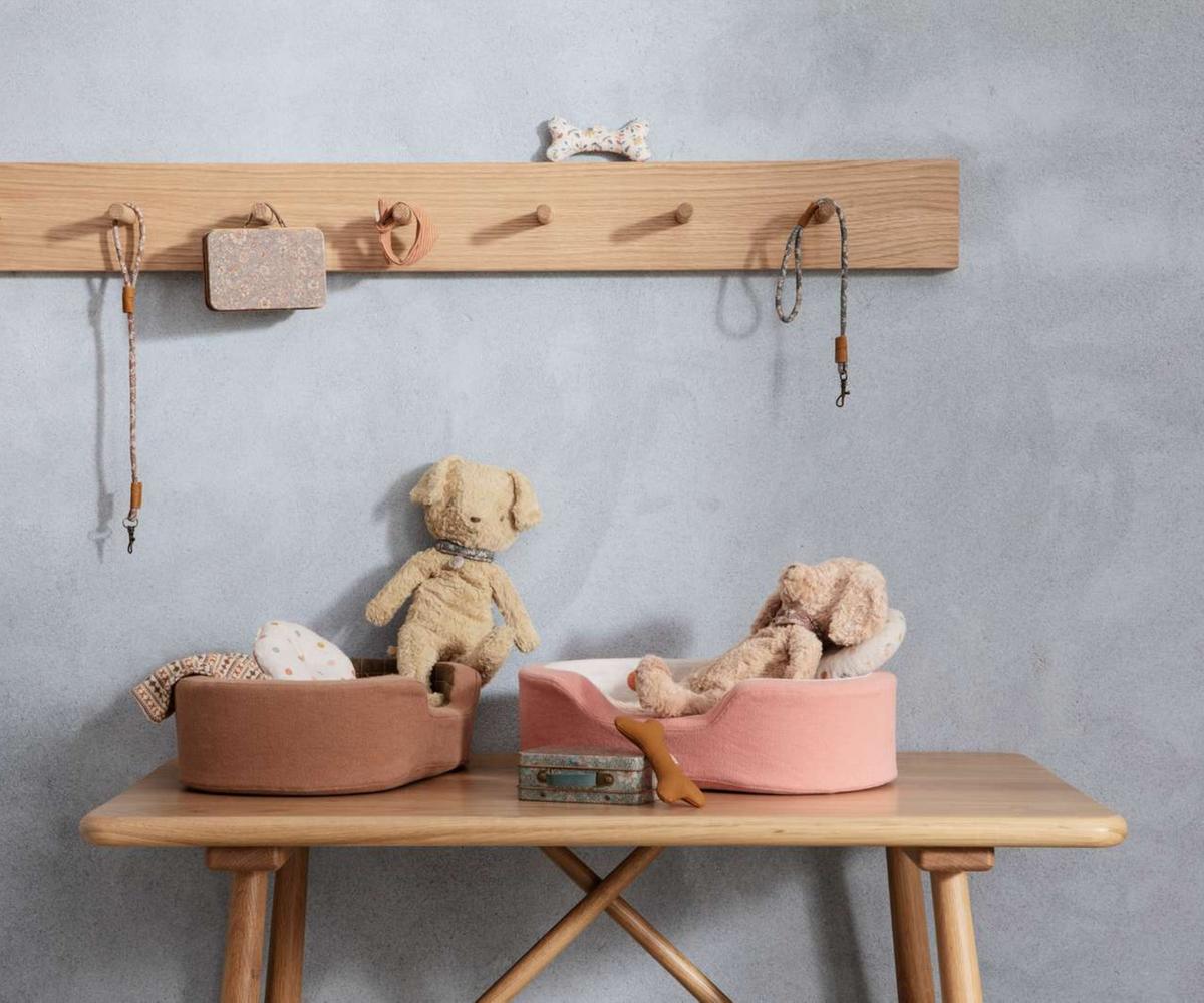 Children's room with wooden shelf, table, and toys against a gray wall.