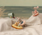 Two toy mice on beach towels with beach accessories