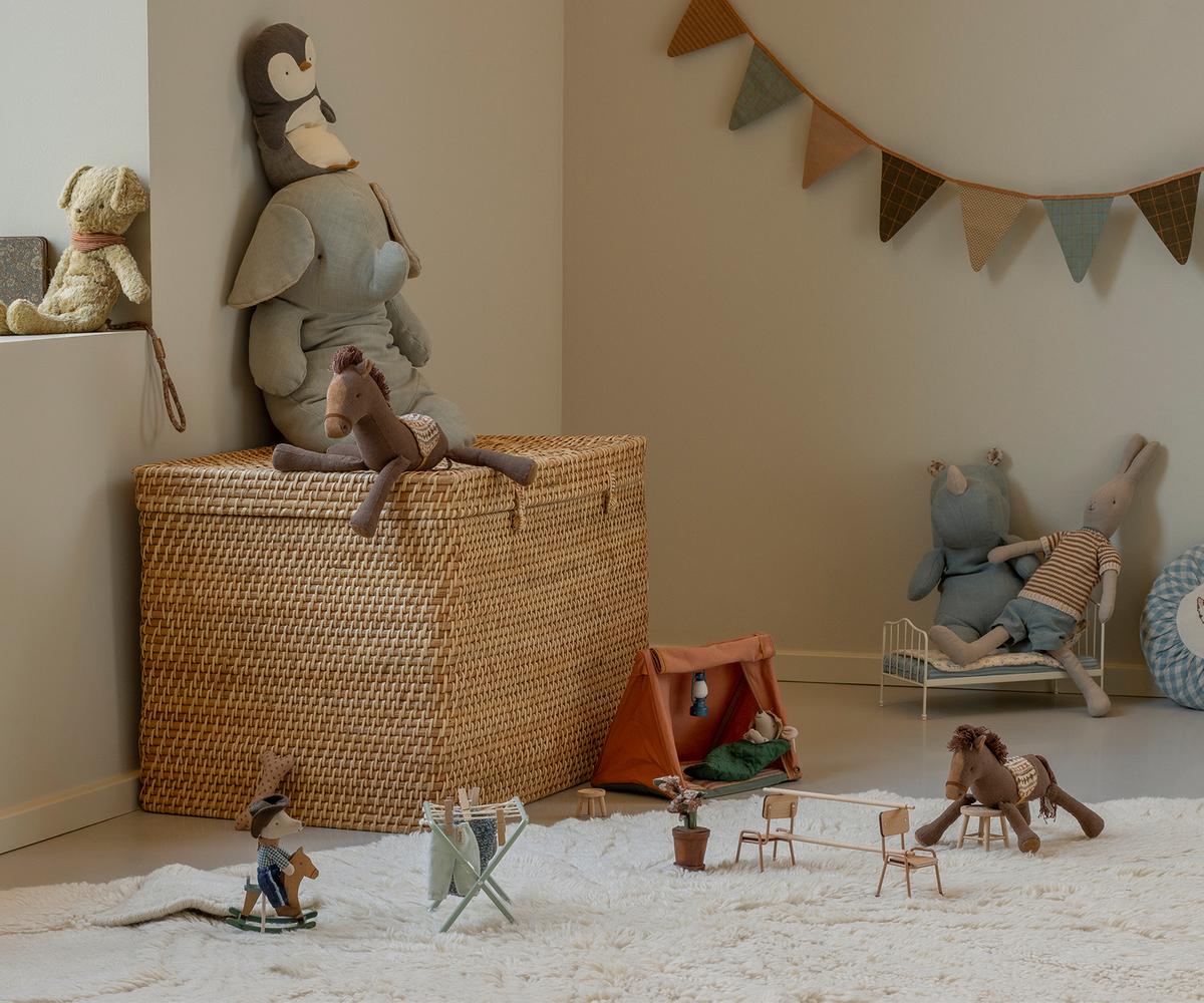 Children's playroom with toys and furniture on a carpeted floor.