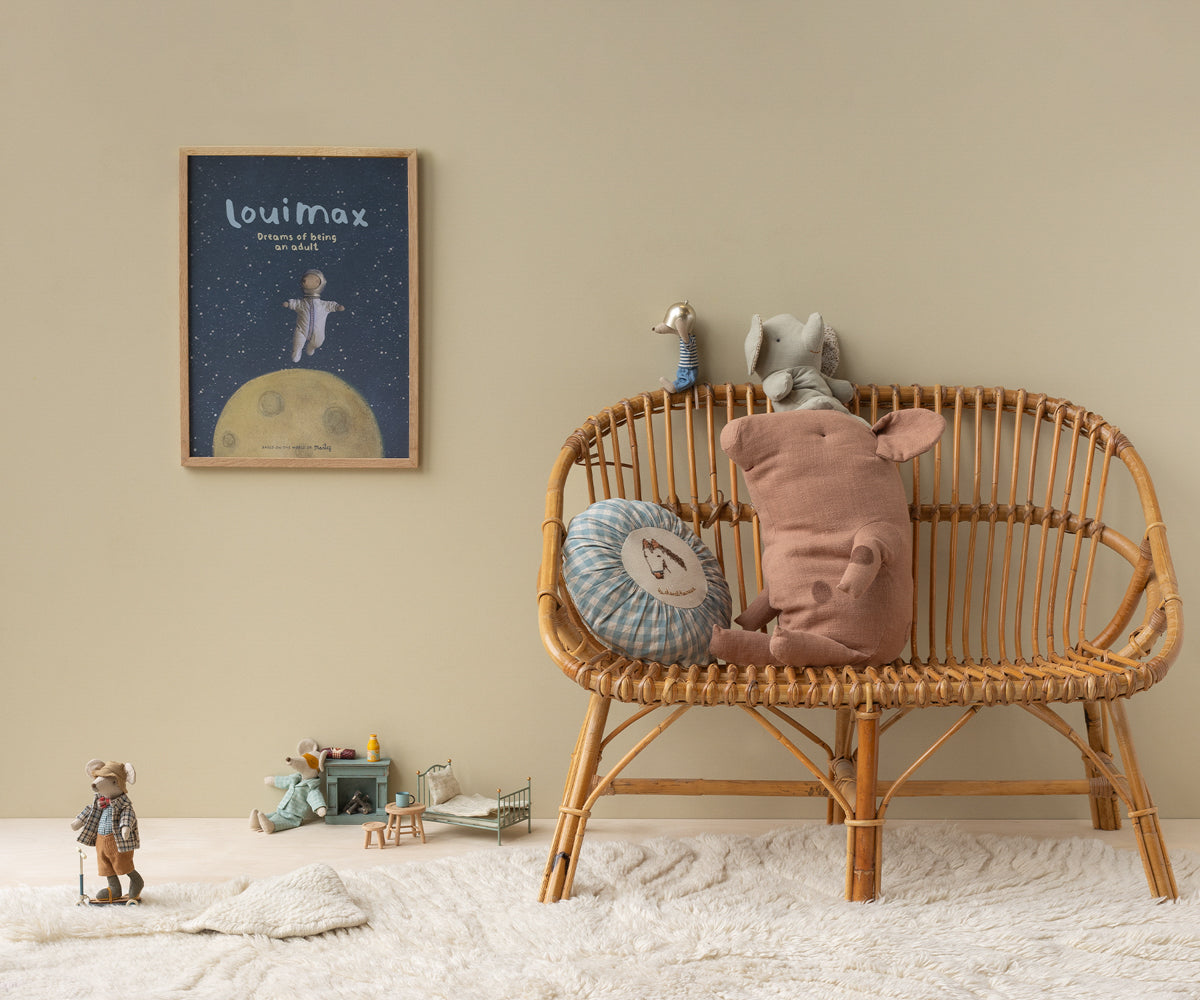 Children's room with a wicker chair, plush toys, and a framed picture on the wall.