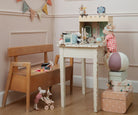 Children's playroom with a small table, chairs, and toys on a wooden floor.