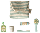 Set of baby care products including a striped pouch, bottle, cup, tube, and brush on a white background.