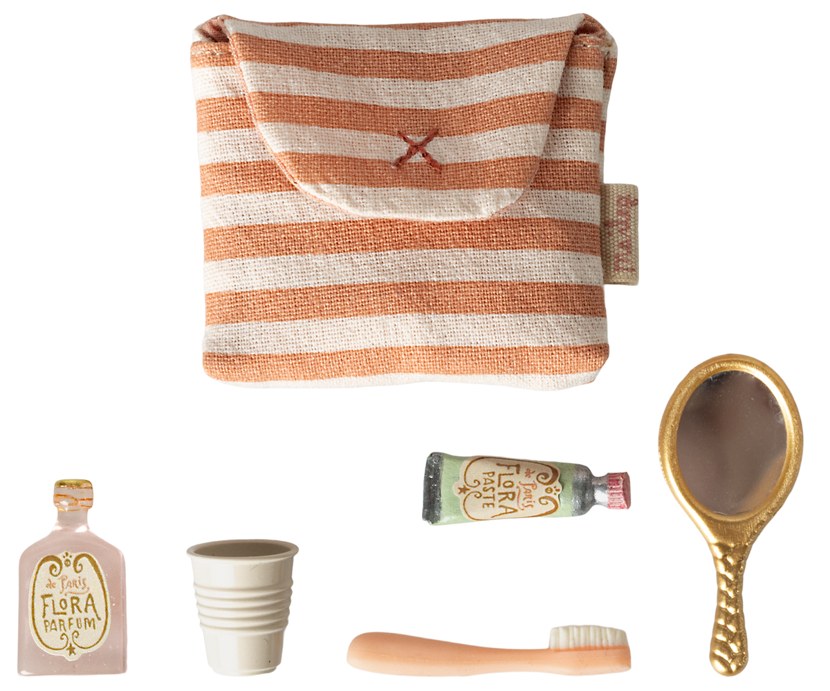 Set of beauty products including a striped pouch, bottles, a cup, and a brush on a white background.