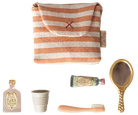 Set of beauty products including a striped pouch, bottles, a cup, and a brush on a white background.