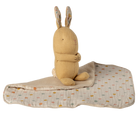 Plush rabbit toy with a patterned blanket on a white background