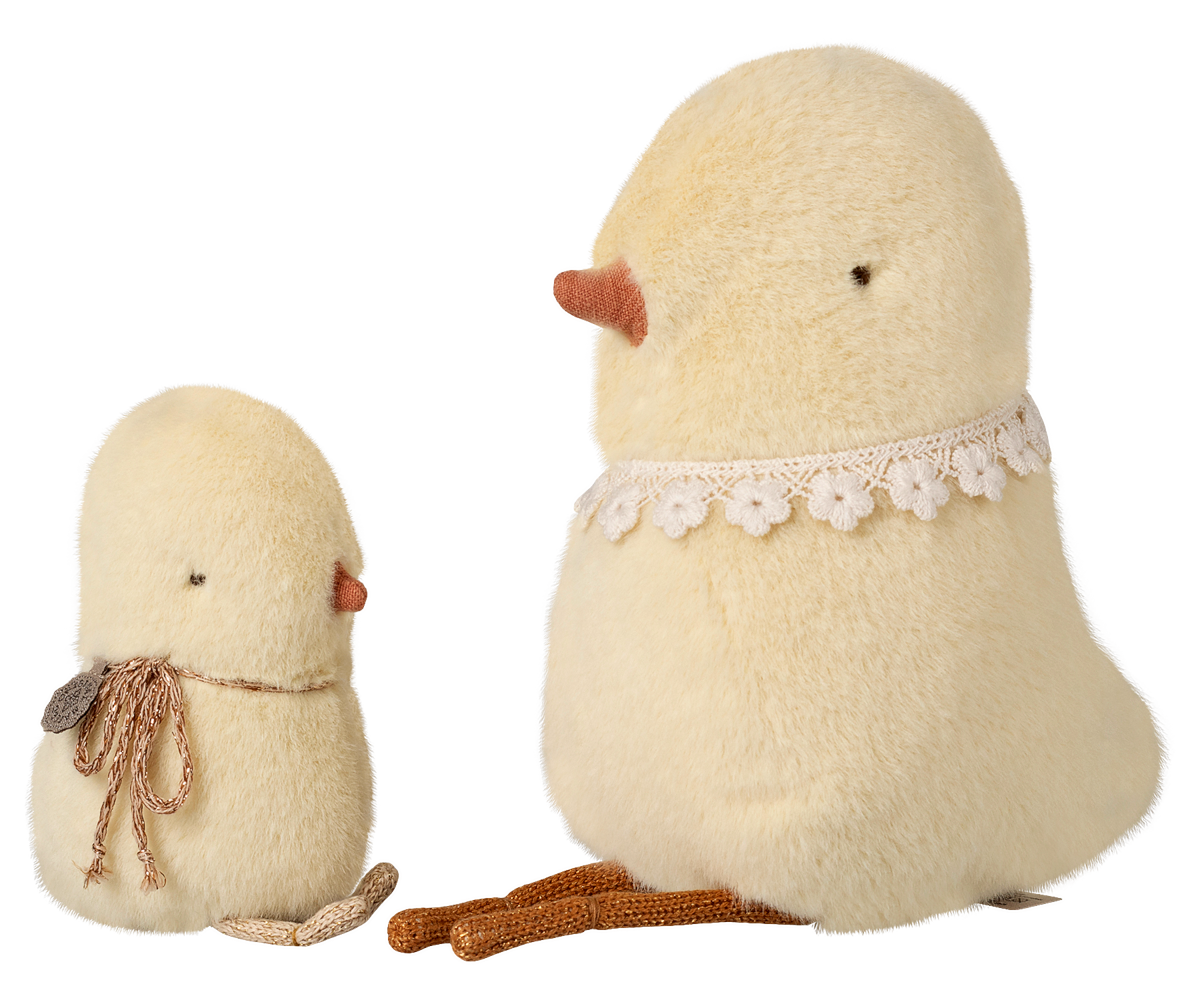 Two fluffy, cream-colored chicks with lace details on a white background