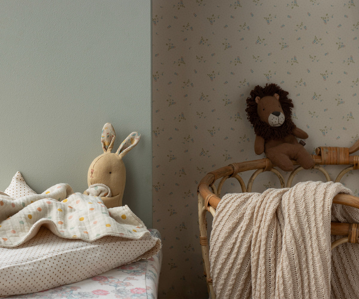 Children's room with stuffed animal on a chair and toys on a bed.