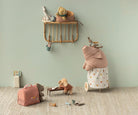 Children's room with toys and a shelf against a light green wall.
