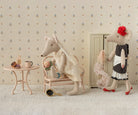 Two plush mice in a decorative room with wallpaper and furniture.