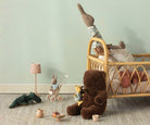 Children's room with toys and a crib against a light green wall.