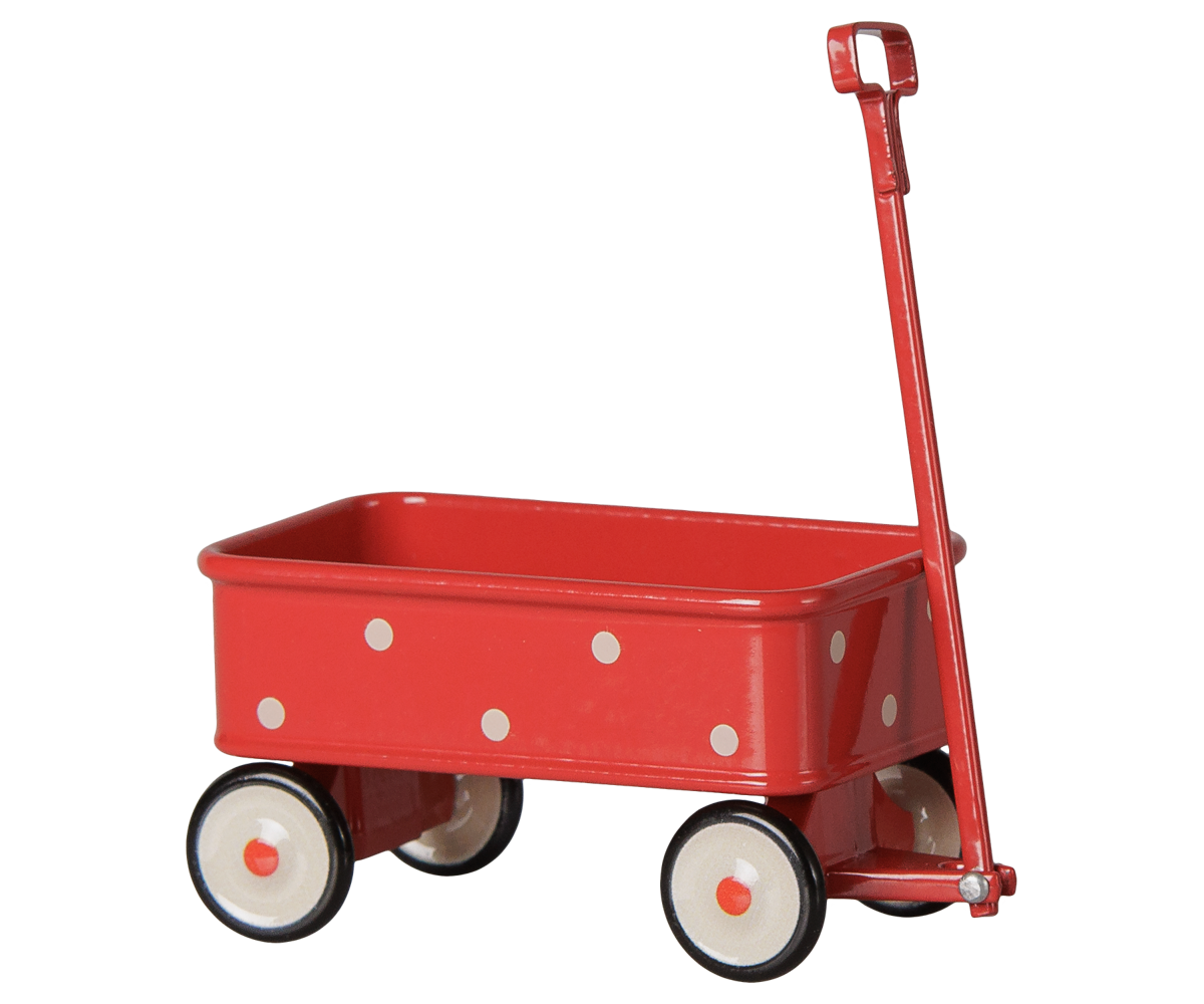 A red metal toy wagon with white polka dots, a red handle, and four wheels with cream-colored rims and black centers, shown on a black background.