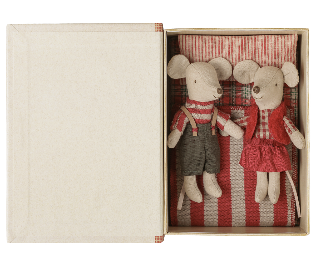 A pair of small plush mouse toys inside an open cream-colored gift box. One mouse wears a red-and-white striped sweater and dark pants, and the other wears a red dress and red-and-white striped top, set against a red-and-white striped fabric background.
