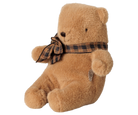 A brown Maileg mini teddy bear sitting with its legs extended forward, wearing a brown and black plaid bow around its neck.