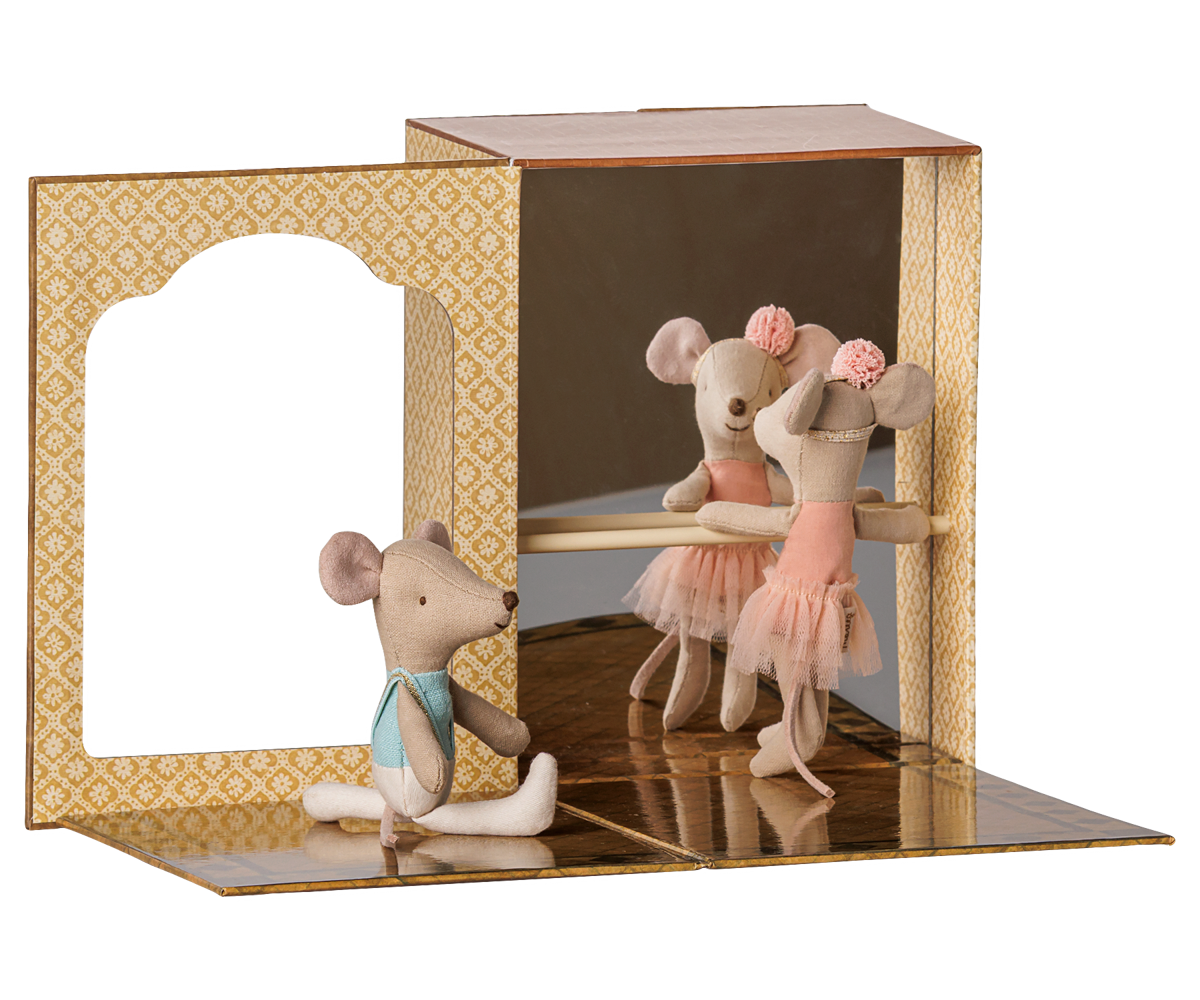 A miniature ballet scene display featuring three small plush mouse ballerina figures in pink tutus around a wooden bar, set inside a decorative patterned cardboard stage with mirrored floor panels.