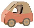 A small toy mouse doll wearing a pink dress, seated inside a cardboard car-shaped playhouse with a peach and tan design, on a plain white background.