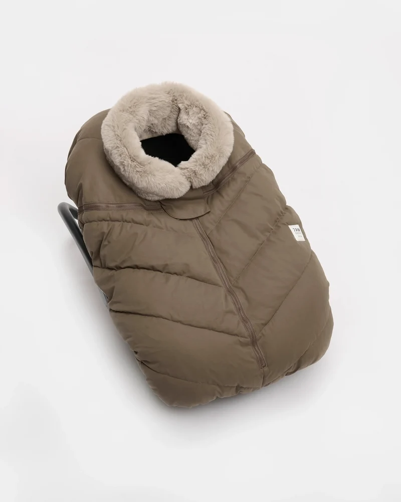 Moss brown Helsinki Car Seat Cocoon by 7AM Enfant showing the front view with a plush faux-fur collar and central zipper.