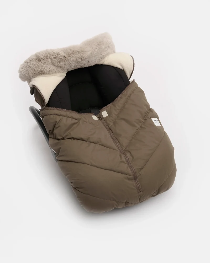 Moss brown Helsinki Car Seat Cocoon by 7AM Enfant showing the front view with a plush faux-fur collar and central zipper.