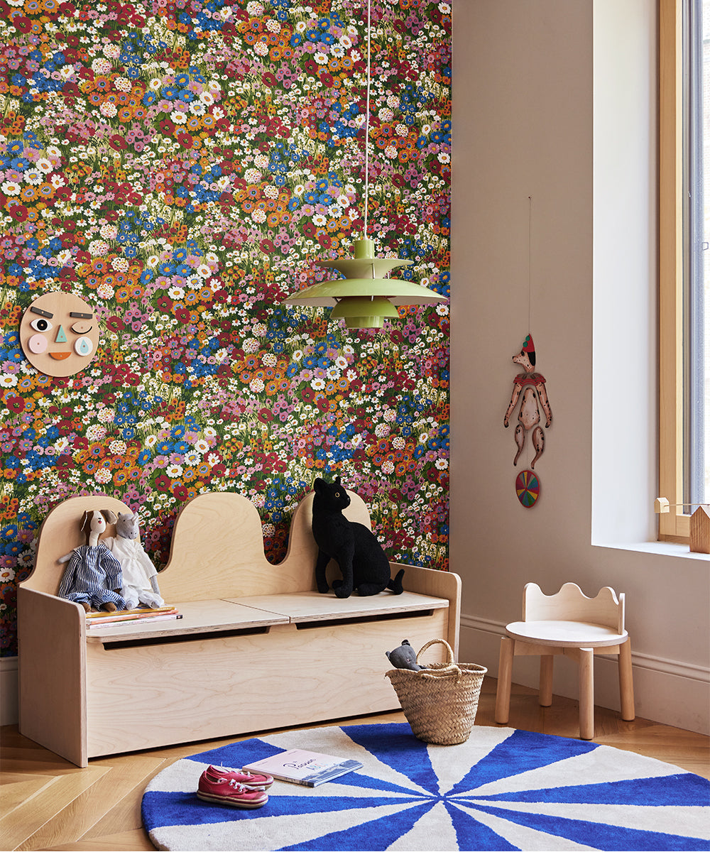 Children's room with floral wallpaper, wooden bench, and colorful rug.