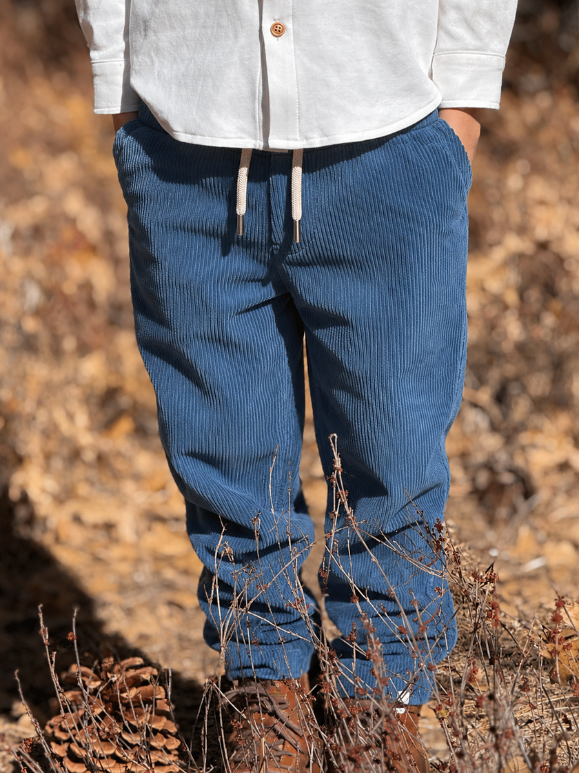 A pair of blue corduroy joggers with an elastic drawstring waist.