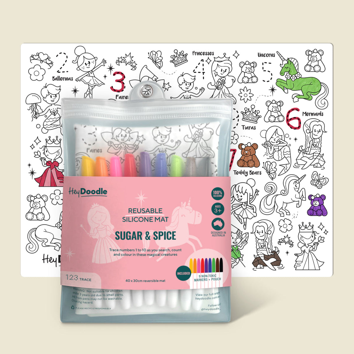 A children's coloring kit shown on a warm beige background, featuring a pink-packaged reusable silicone mat with built-in color pens and a printed coloring page with princess and fantasy illustrations.