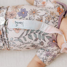 Floral-patterned baby outfit with a visible brand label on a soft background