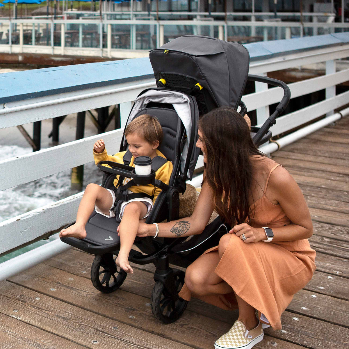 Woman with a child in a stroller by a waterfront