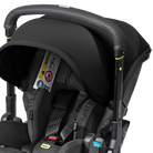Black car seat with stroller attachment on a black background