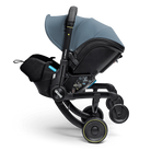 Black and gray stroller with a baby seat on a white background