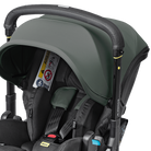 Close-up of a stroller with a dark sage green canopy and black frame, fitted with a black infant car seat. A Velcro airbag is attached to the side, and the brand names 'Mammoth' and 'Baby Jogger' are visible.