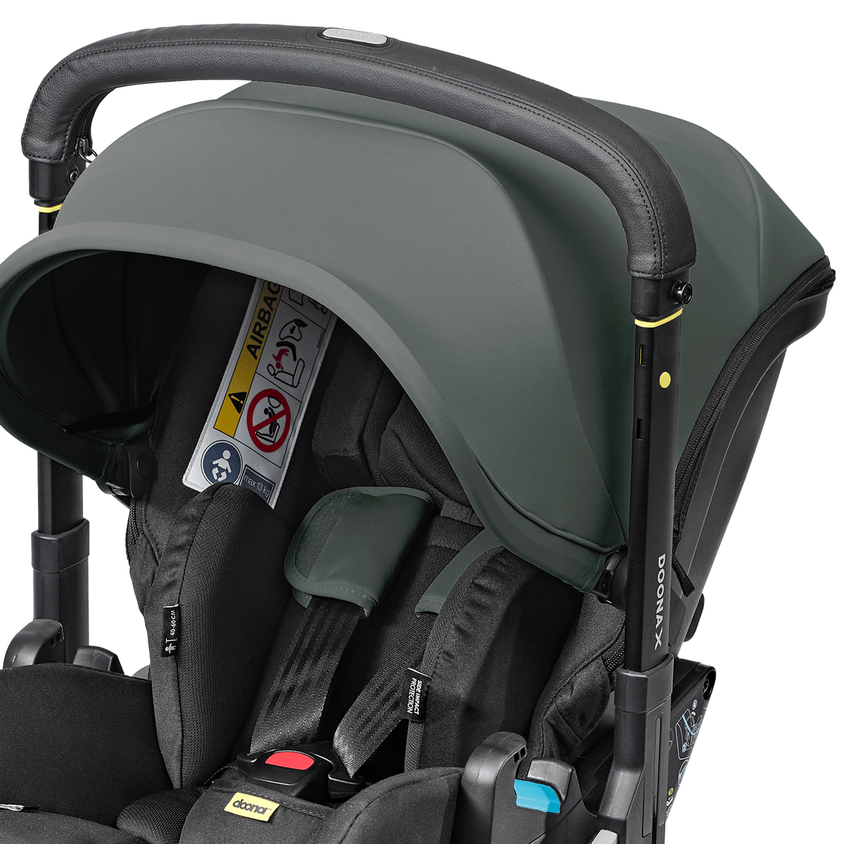 Close-up of a stroller with a dark sage green canopy and black frame, fitted with a black infant car seat. A Velcro airbag is attached to the side, and the brand names 'Mammoth' and 'Baby Jogger' are visible.