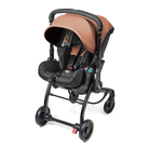 A compact stroller and car seat travel system in black and tan/caramel, shown on a clean white background. The stroller features a black frame with four wheels, a black car seat base, and a tan canopy and interior padding.