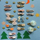 Collection of colorful hair accessories on a blue background with decorative items.