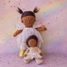 Two dolls with white outfits on a colorful polka dot background