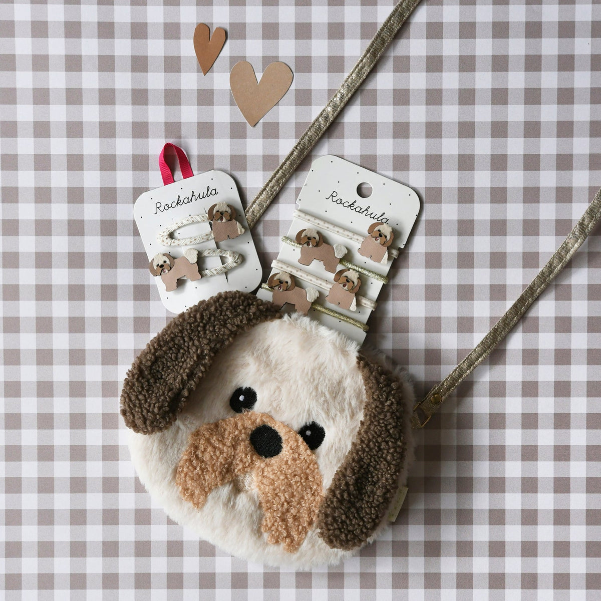 Dog-shaped hair clip and hair ties on a checkered background