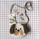 Dog-shaped pouch with a strap and heart-shaped earrings on a checkered background