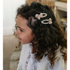 Child with curly hair wearing a headband with animal designs.