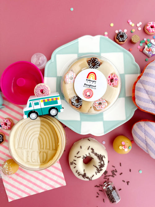 Decorative donut press with a pink background and donuts around it