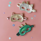 Three colorful masks on a pink background with star decorations