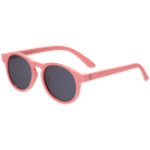 Pink sunglasses with dark lenses on a white background