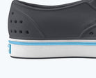 Close-up of a shoe sole with gray, white, and blue color scheme on a white background