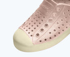 Close-up of a pink slip-on shoe with a white background