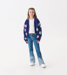 Person wearing a blue jacket and blue denim jeans with a subtle heart pattern.
