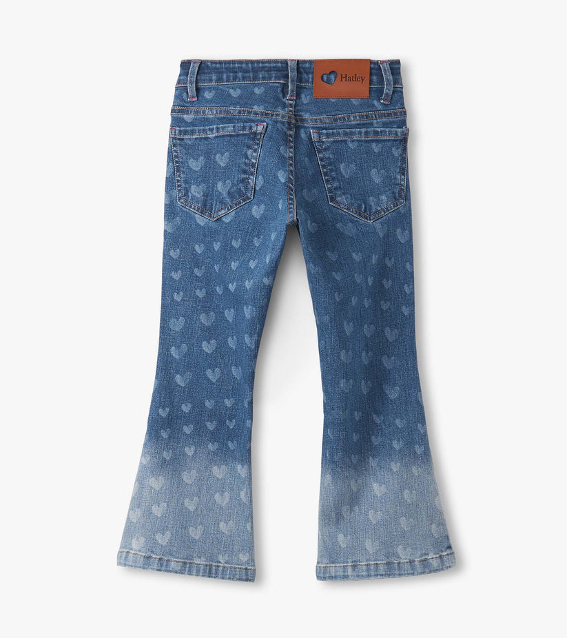 A pair of blue denim jeans with a subtle heart pattern and a faded wash at the hem with hatley tag shown against a plain white background.
