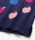 Close-up of a navy blue knit garment with a pattern of pink and light pink apples, featuring a ribbed hem.